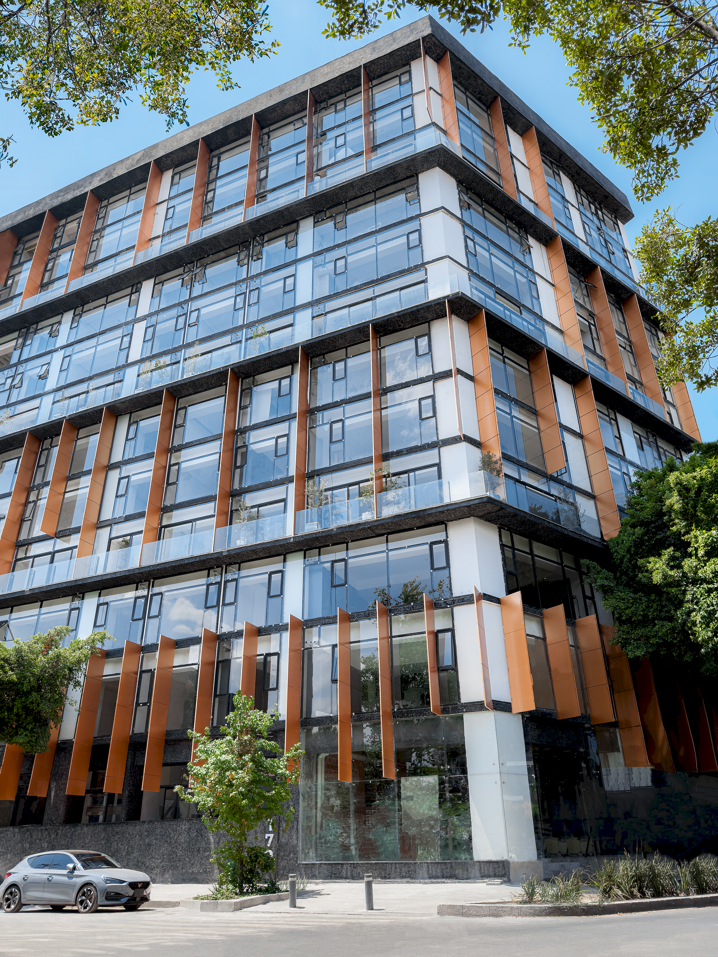 Fachada exterior de ICON Roma entre árboles y cielo azul